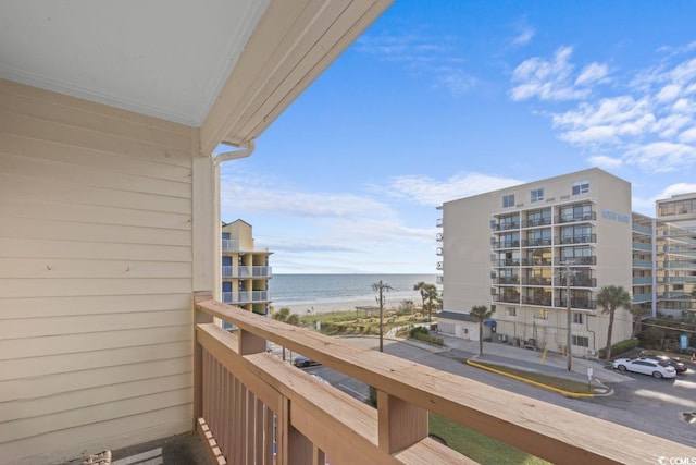 balcony with a water view and a view of the beach