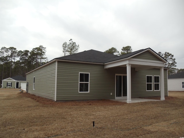 back of house with a lawn and a patio