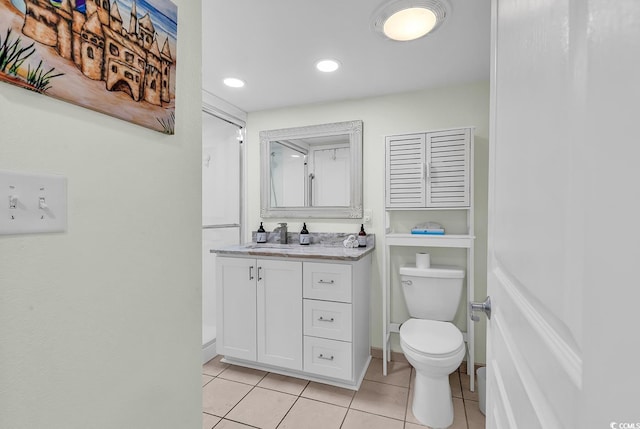 bathroom with tile patterned flooring, vanity, and toilet