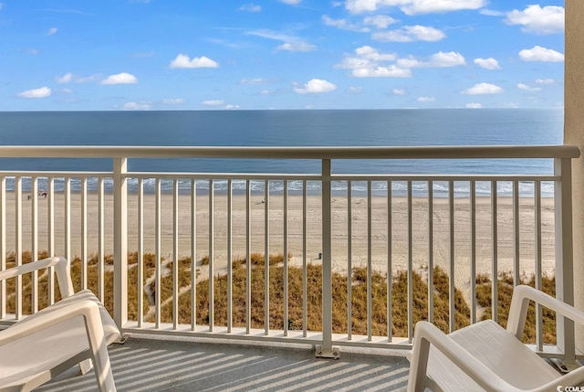 balcony with a water view and a view of the beach