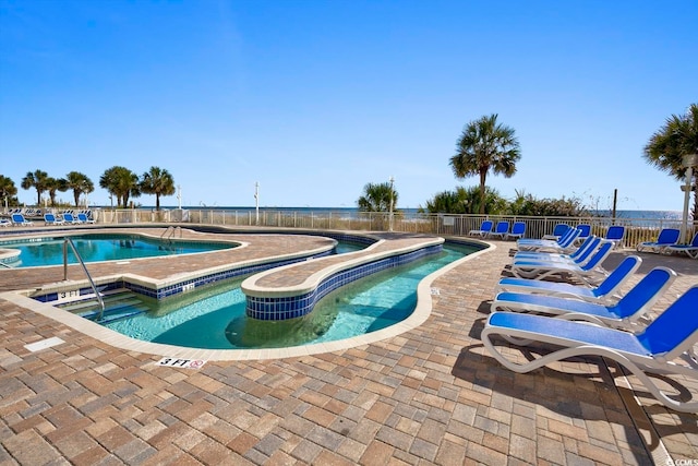 view of swimming pool with a water view and a patio