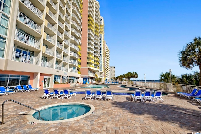 view of swimming pool with a community hot tub