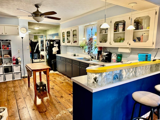 kitchen featuring pendant lighting, a textured ceiling, light hardwood / wood-style floors, and white cabinetry