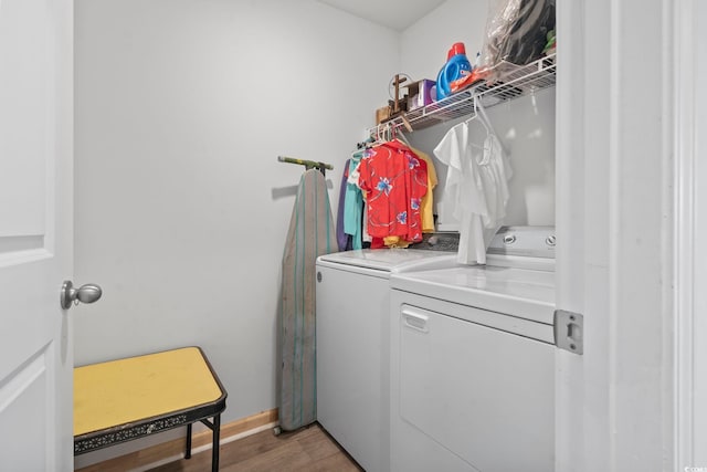 washroom with washer and clothes dryer and hardwood / wood-style floors