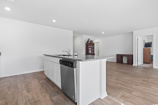 kitchen featuring white cabinets, sink, stainless steel dishwasher, an island with sink, and wood-type flooring