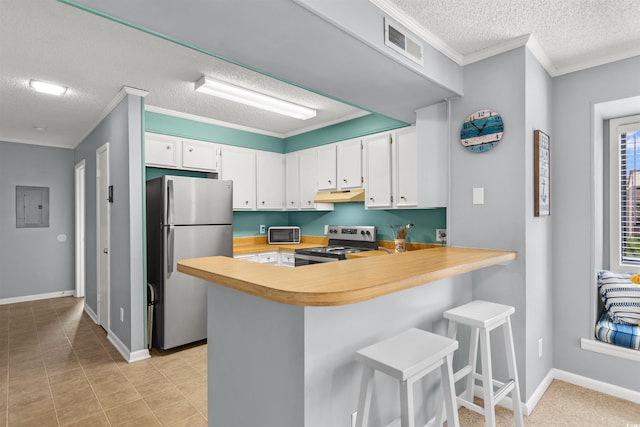 kitchen featuring a kitchen breakfast bar, kitchen peninsula, white cabinets, and stainless steel appliances