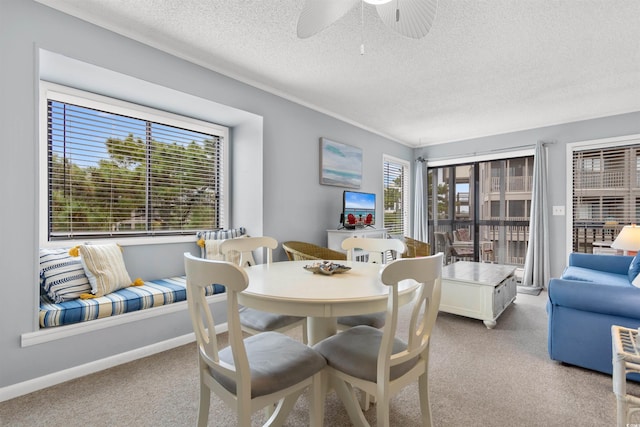 dining room featuring a textured ceiling, light colored carpet, and ceiling fan