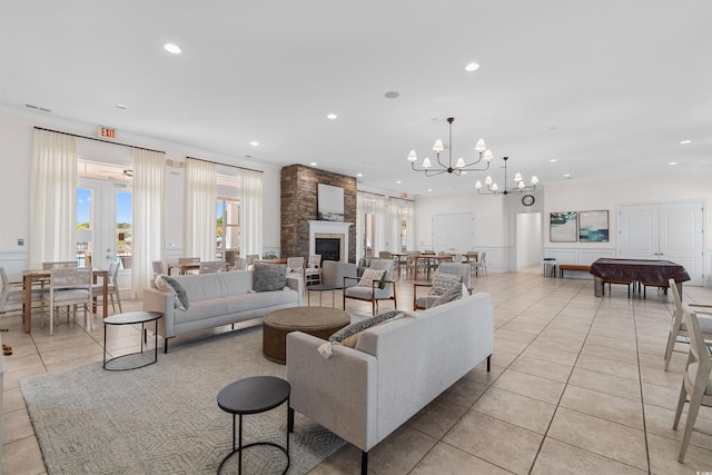 tiled living room featuring an inviting chandelier and a fireplace