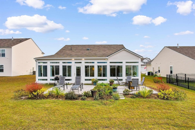 rear view of property featuring central AC, a sunroom, a lawn, and a patio