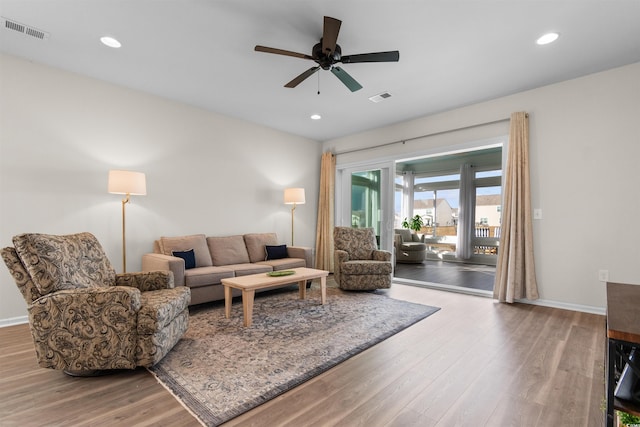 living room featuring light hardwood / wood-style flooring and ceiling fan