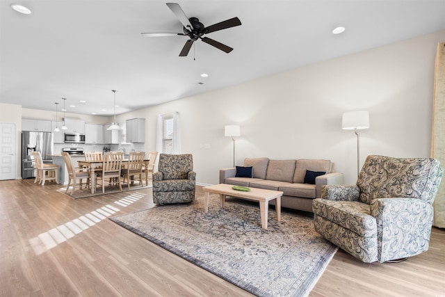 living room featuring ceiling fan and light hardwood / wood-style floors