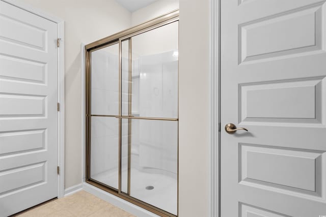 bathroom featuring tile patterned flooring and a shower with shower door