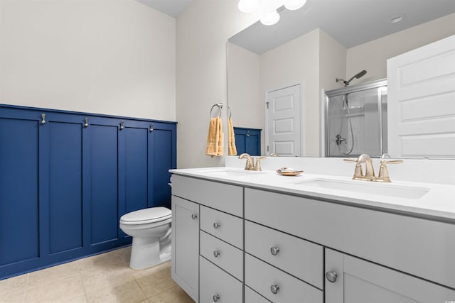 bathroom with a shower with door, tile patterned floors, toilet, and vanity