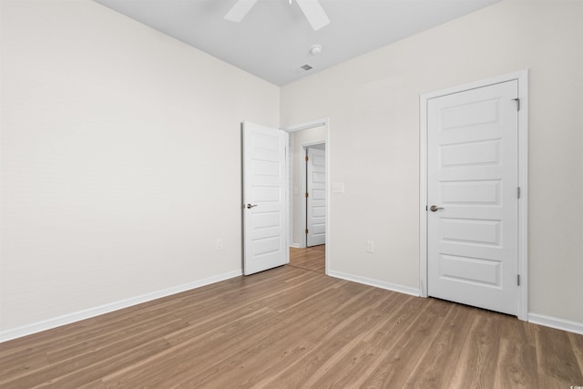 unfurnished bedroom with ceiling fan, hardwood / wood-style floors, and a closet