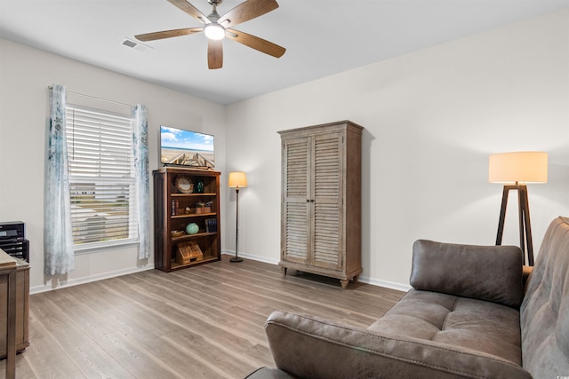 living room with light wood-type flooring and ceiling fan