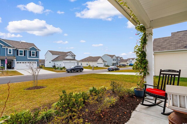 view of yard featuring a garage and covered porch