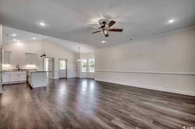 unfurnished living room with dark wood finished floors, lofted ceiling, a sink, and ceiling fan with notable chandelier