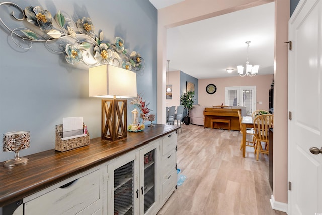 kitchen featuring wood counters, french doors, light wood-type flooring, decorative light fixtures, and a chandelier