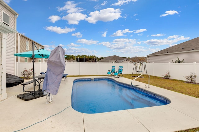 view of pool with a lawn and a patio area