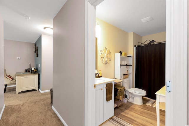 bathroom featuring hardwood / wood-style floors, vanity, a shower with shower curtain, and toilet