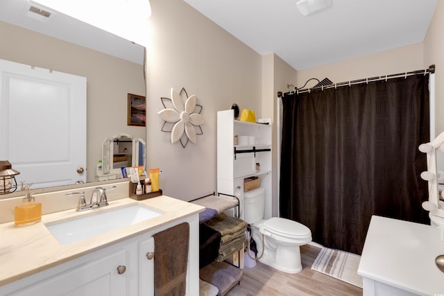 bathroom featuring a shower with shower curtain, hardwood / wood-style floors, vanity, and toilet