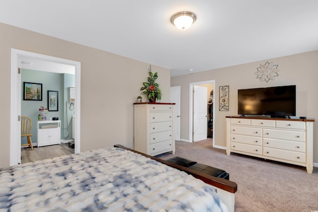 bedroom featuring a walk in closet, ensuite bathroom, a closet, and light colored carpet