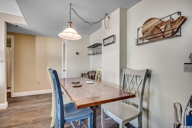 dining area with a textured ceiling and hardwood / wood-style flooring