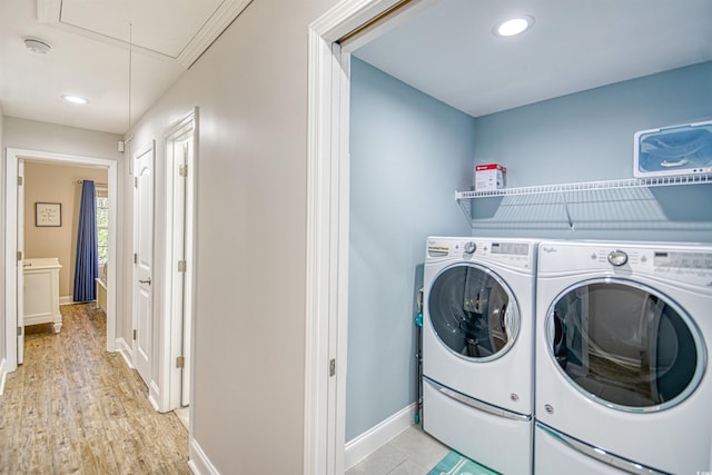 laundry room featuring washer and dryer and light hardwood / wood-style floors