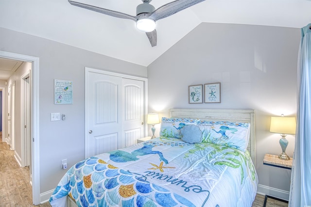 bedroom with wood-type flooring, vaulted ceiling, a closet, and ceiling fan