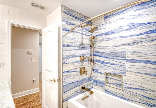 bathroom with wood-type flooring and tiled shower / bath combo