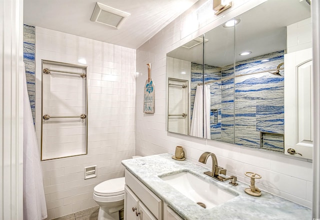 bathroom featuring vanity, toilet, tile walls, and curtained shower