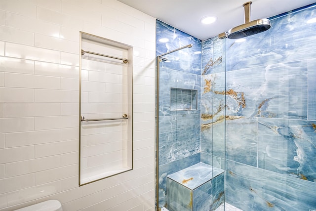 bathroom featuring a tile shower and toilet