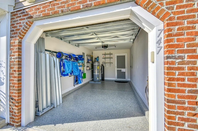 garage featuring a garage door opener and water heater