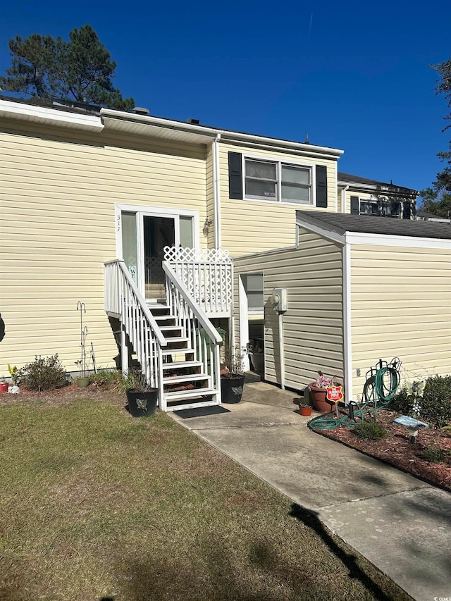 property entrance featuring a lawn