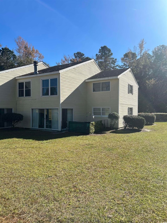 rear view of property with a lawn