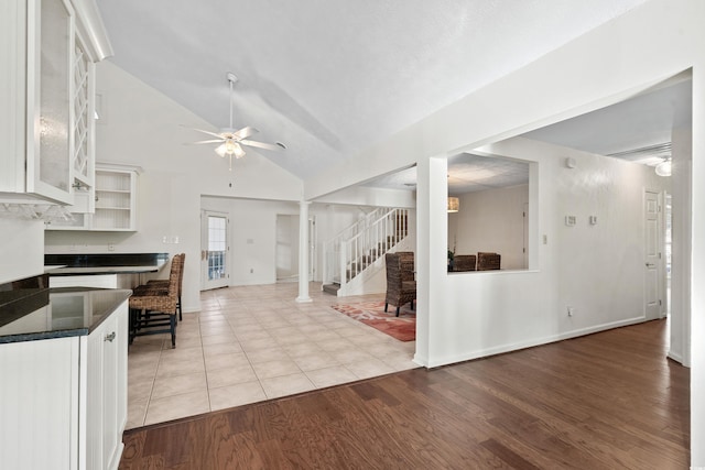 kitchen with ornate columns, lofted ceiling, white cabinets, ceiling fan, and light hardwood / wood-style flooring