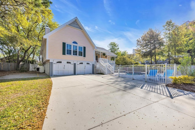 view of side of home with a garage, fence, a chimney, driveway, and stairs