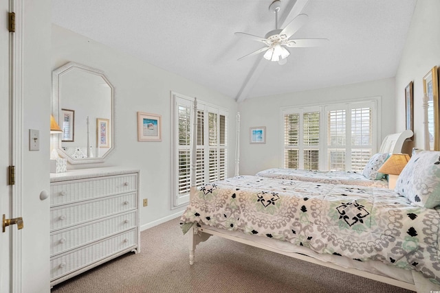 carpeted bedroom featuring vaulted ceiling, ceiling fan, and a textured ceiling