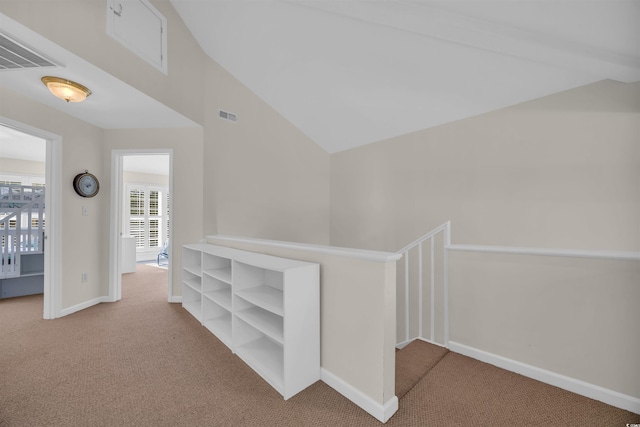 hall featuring baseboards, visible vents, and carpet floors