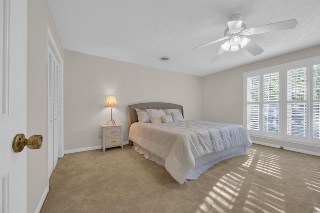 carpeted bedroom featuring baseboards, ceiling fan, and visible vents