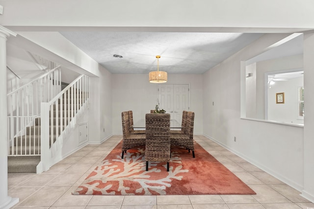 tiled dining room featuring a textured ceiling