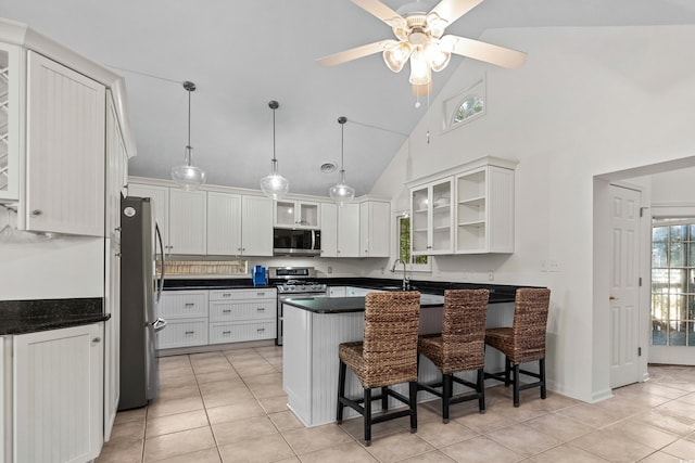 kitchen featuring decorative light fixtures, a kitchen breakfast bar, white cabinets, and appliances with stainless steel finishes