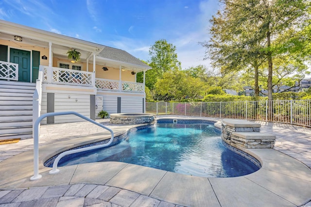 view of swimming pool with a pool with connected hot tub, fence, and a patio