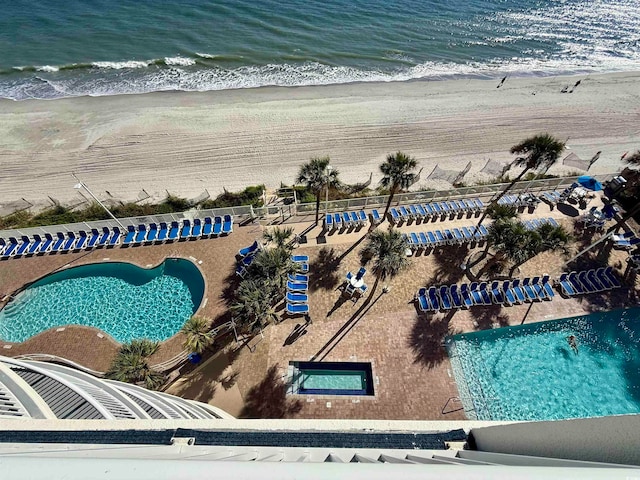 birds eye view of property featuring a water view and a beach view