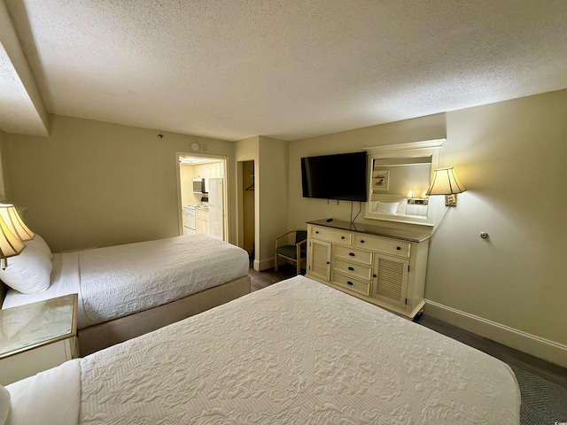 bedroom featuring a walk in closet, a textured ceiling, and a closet