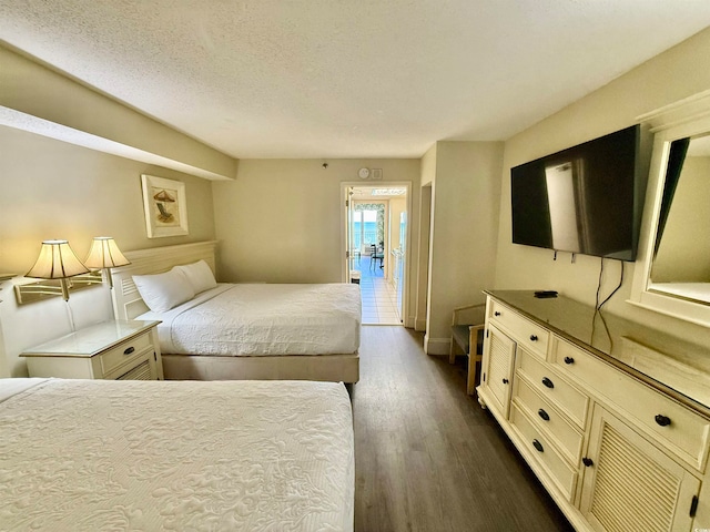 bedroom with dark hardwood / wood-style flooring and a textured ceiling