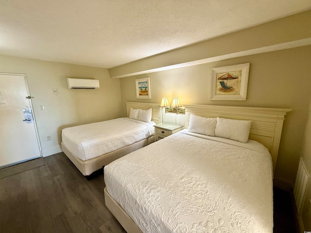 bedroom with a wall unit AC and dark wood-type flooring