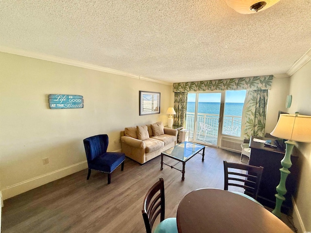 living room featuring crown molding, a water view, a textured ceiling, and hardwood / wood-style flooring