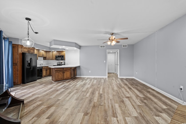 kitchen featuring light wood-type flooring, decorative light fixtures, ceiling fan, and black appliances