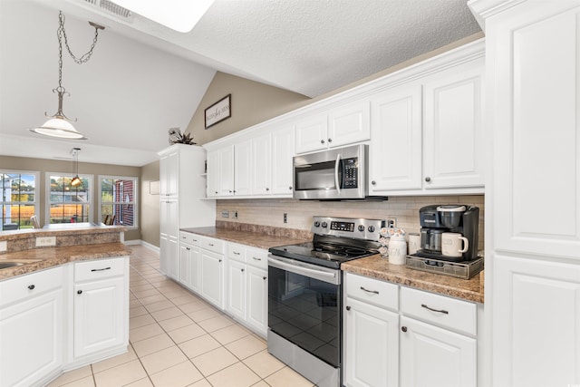 kitchen featuring lofted ceiling, light tile patterned floors, hanging light fixtures, appliances with stainless steel finishes, and tasteful backsplash